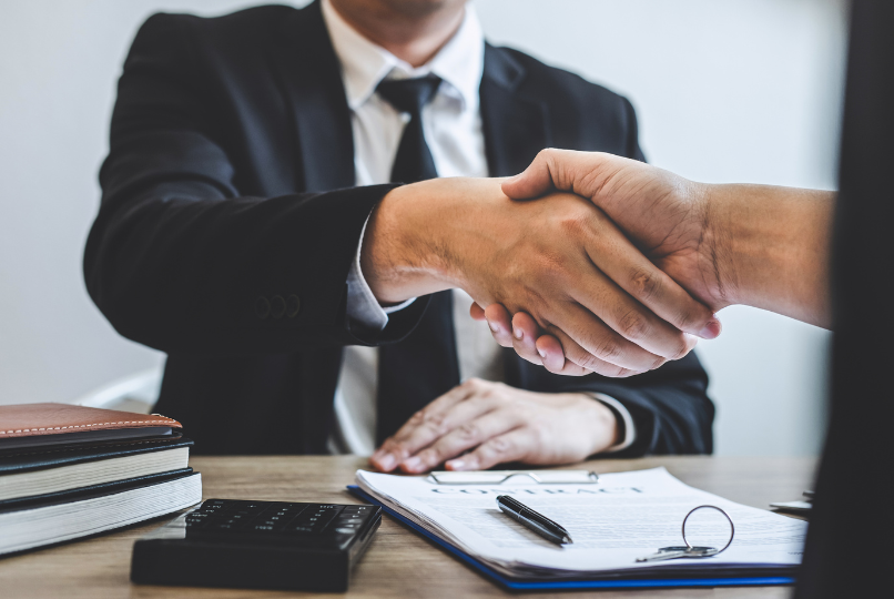 About Us - SLP advisor shaking hands with client during student loan consultation.